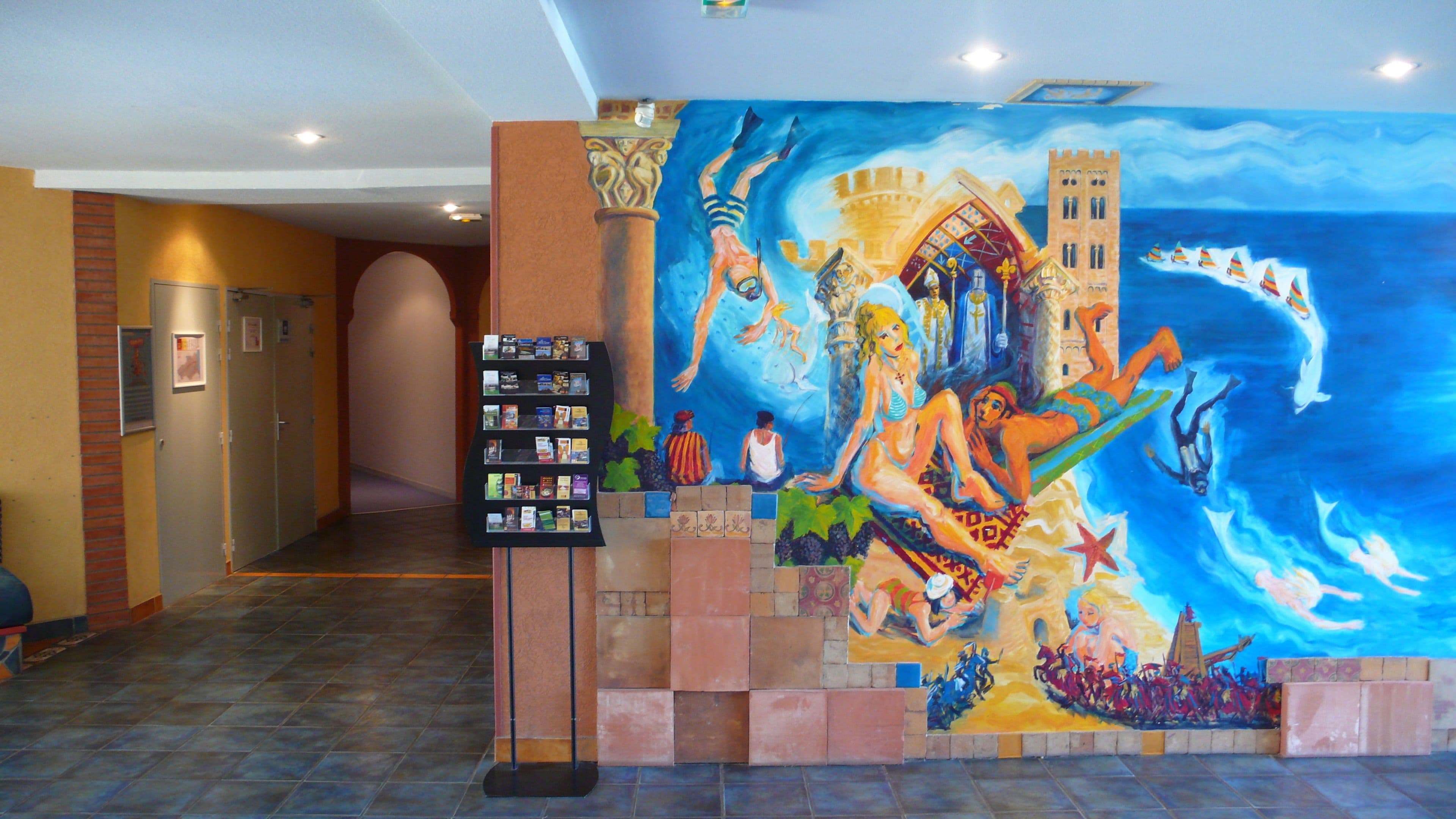 A hallway with a mural depicting a historical scene, a book display, and a tiled floor.