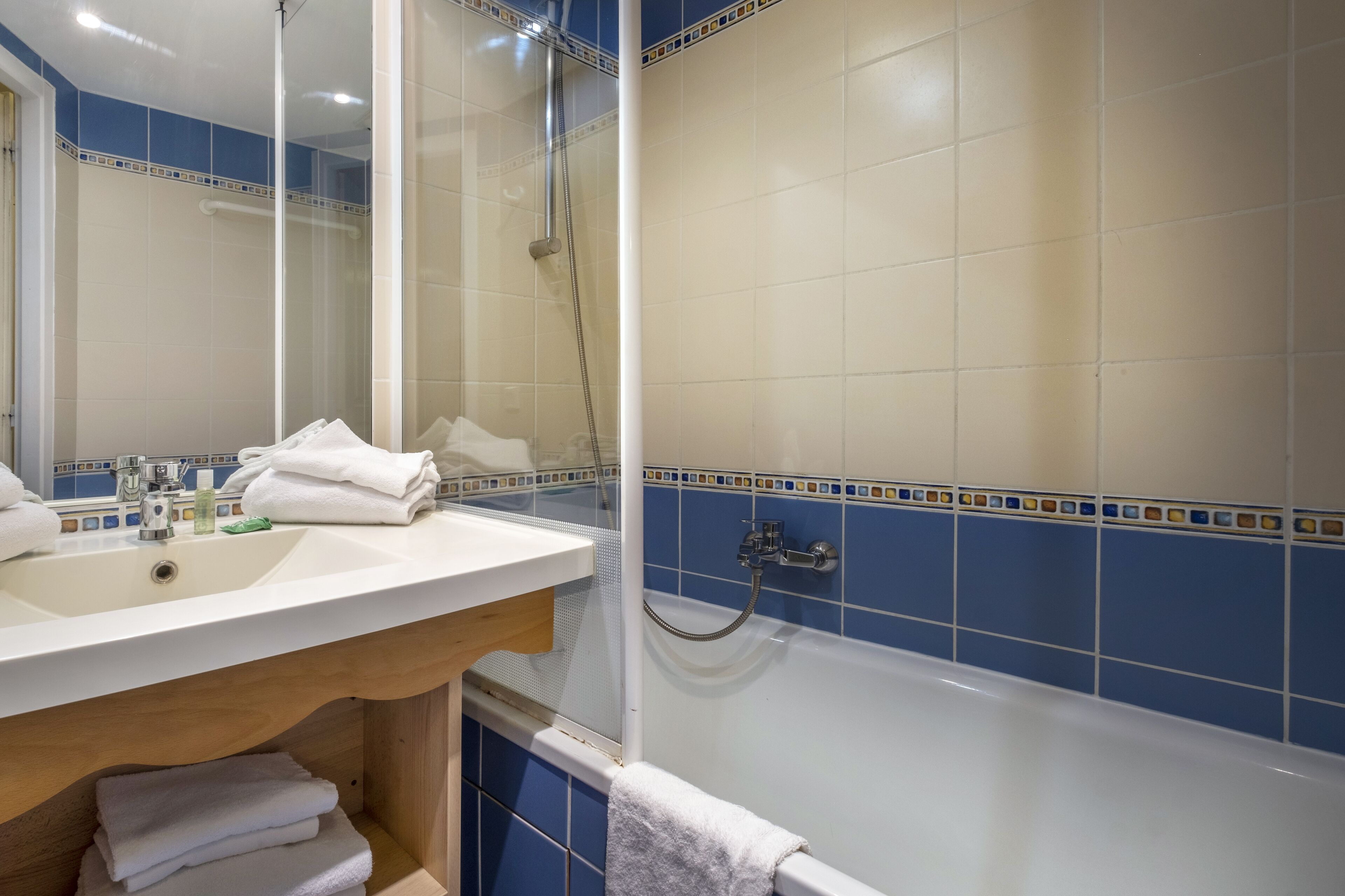 Un baño con bañera, lavamanos y espejo.