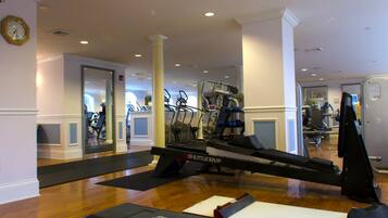 Un gimnasio con cintas de correr, elípticas y una máquina de remo.