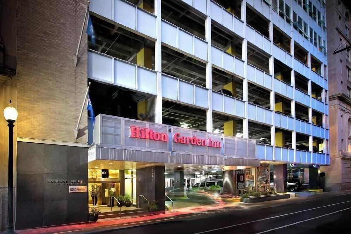 Un Hilton Garden Inn con un estacionamiento de varios pisos y una entrada bien iluminada.