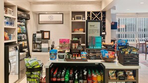 Ein Verkaufsbereich mit Kühlregalen, beschriftet mit 'CHILLED' und 'FROZEN', Regale voller Snacks und eine Auswahl an regionalen Spezialitäten.