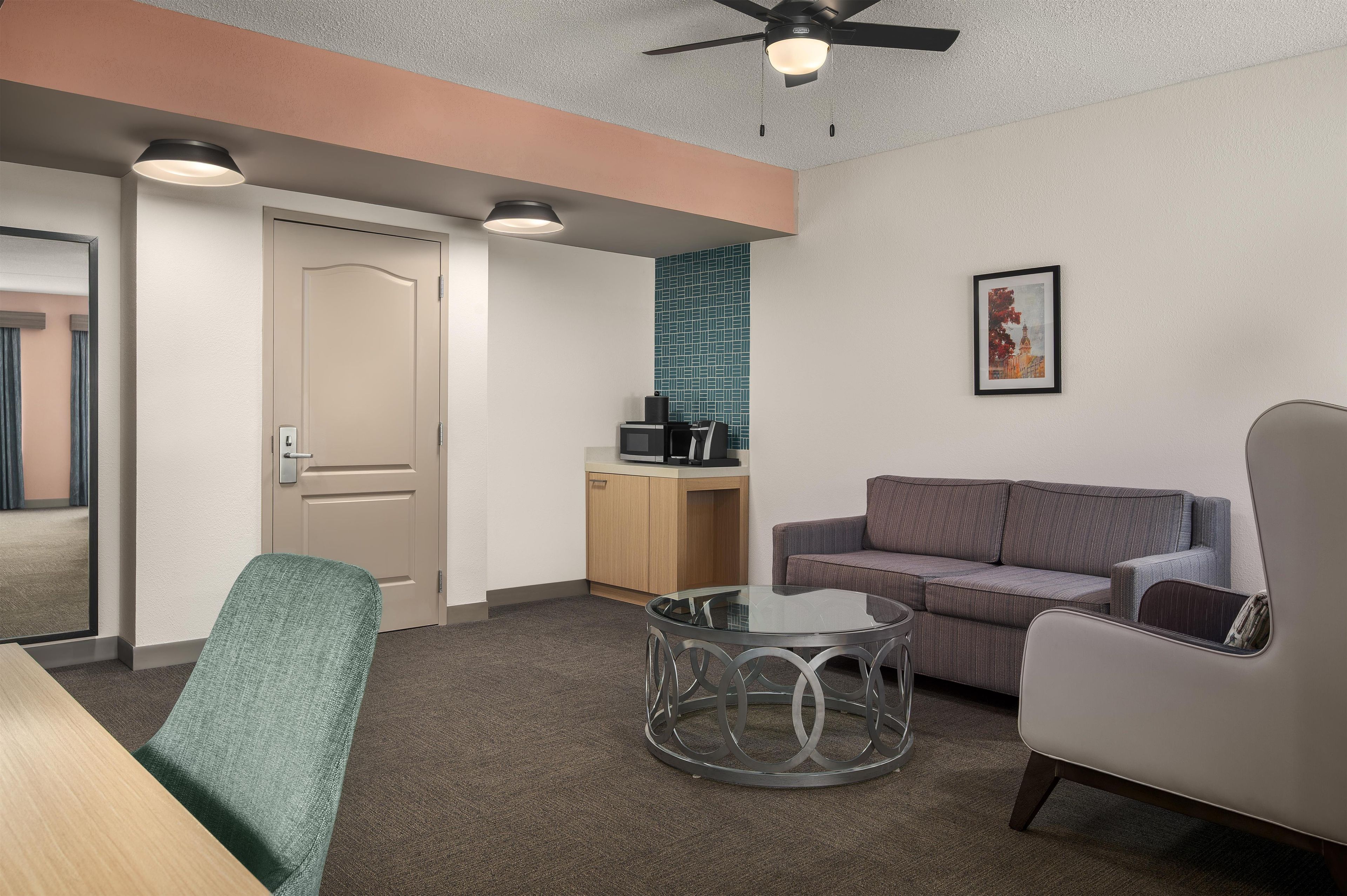 A modern room with a sofa, armchair, and coffee table.