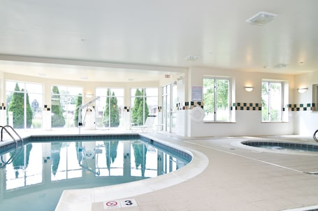 Una piscina techada, sillones reclinables de piscina