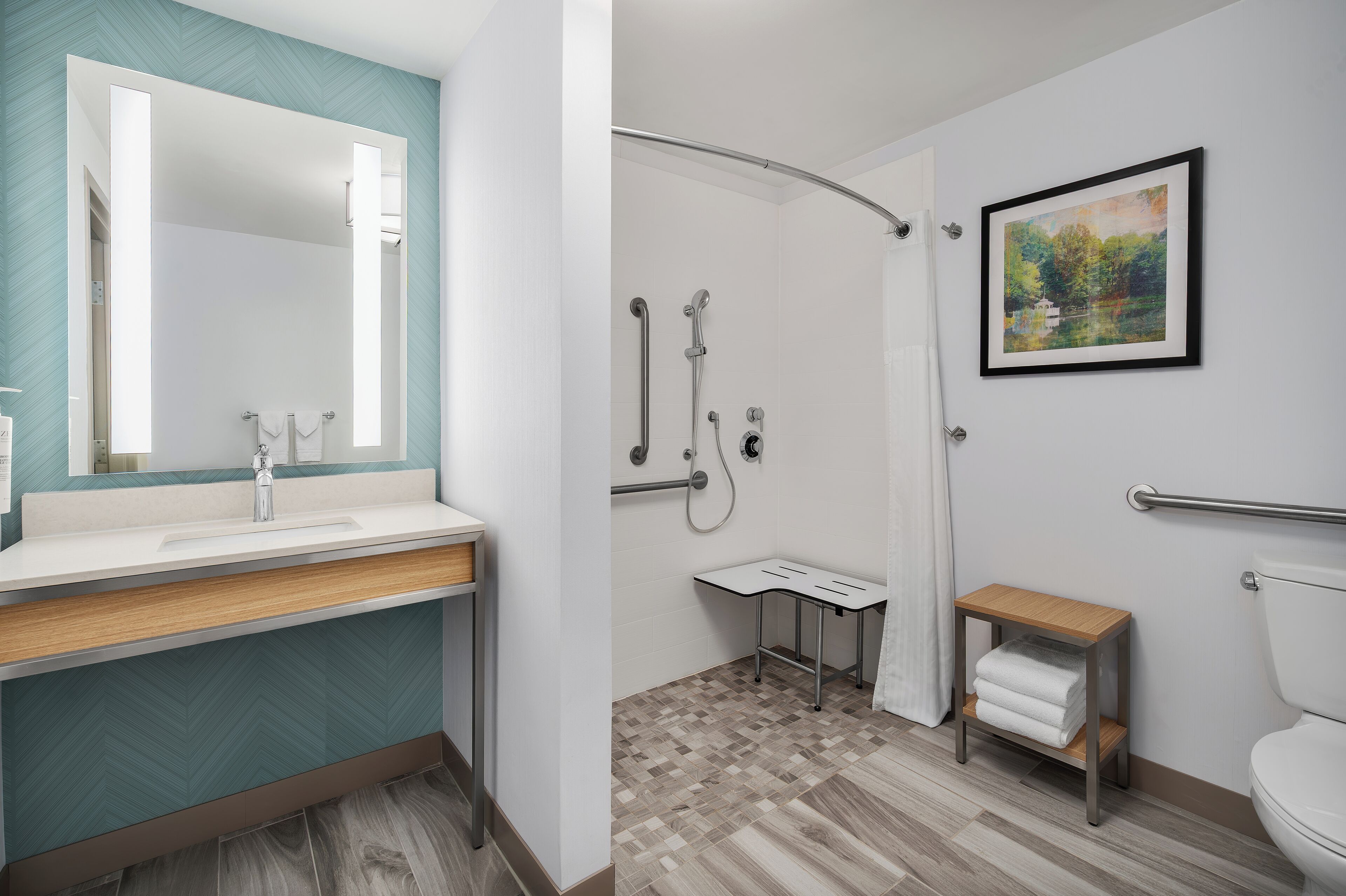 A modern bathroom with a large mirror, a shower, and a toilet.