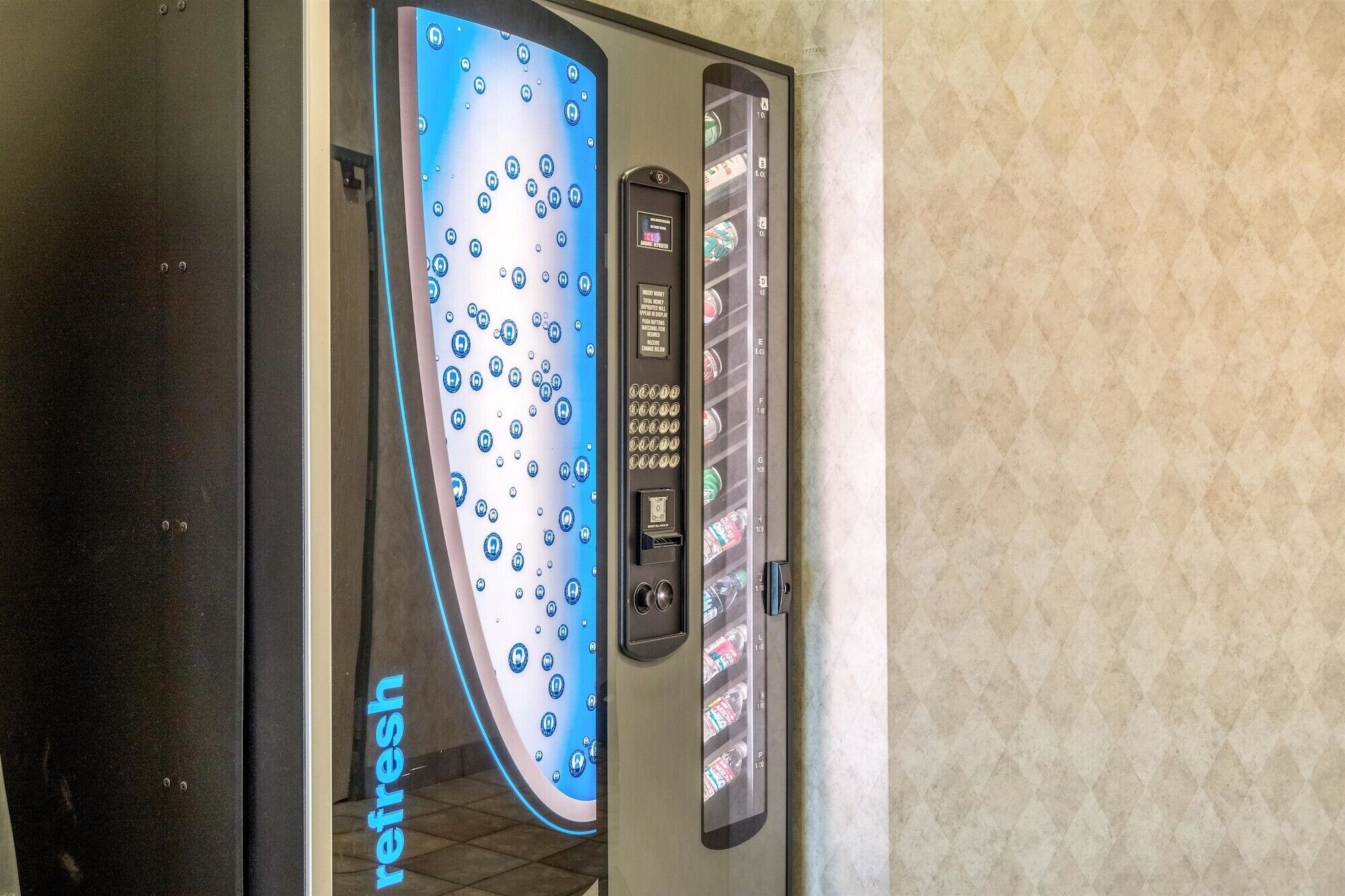 A vending machine with a 'refresh' label, a digital display, and a coin slot.