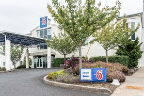 Ein Schild von Motel 6 mit einem Pfeil, der nach links zeigt und den Eingang anweist.