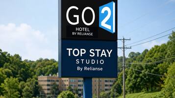A sign for GO 2 Hotel by Reliance, indicating a Top Stay Studio.