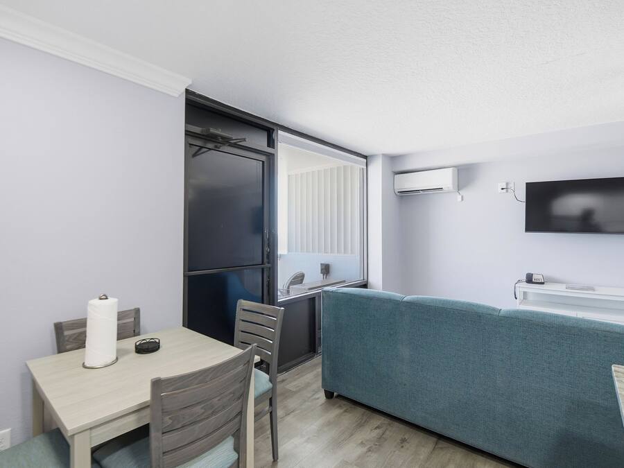 A compact living space with a kitchenette, a dining area, and a seating area.