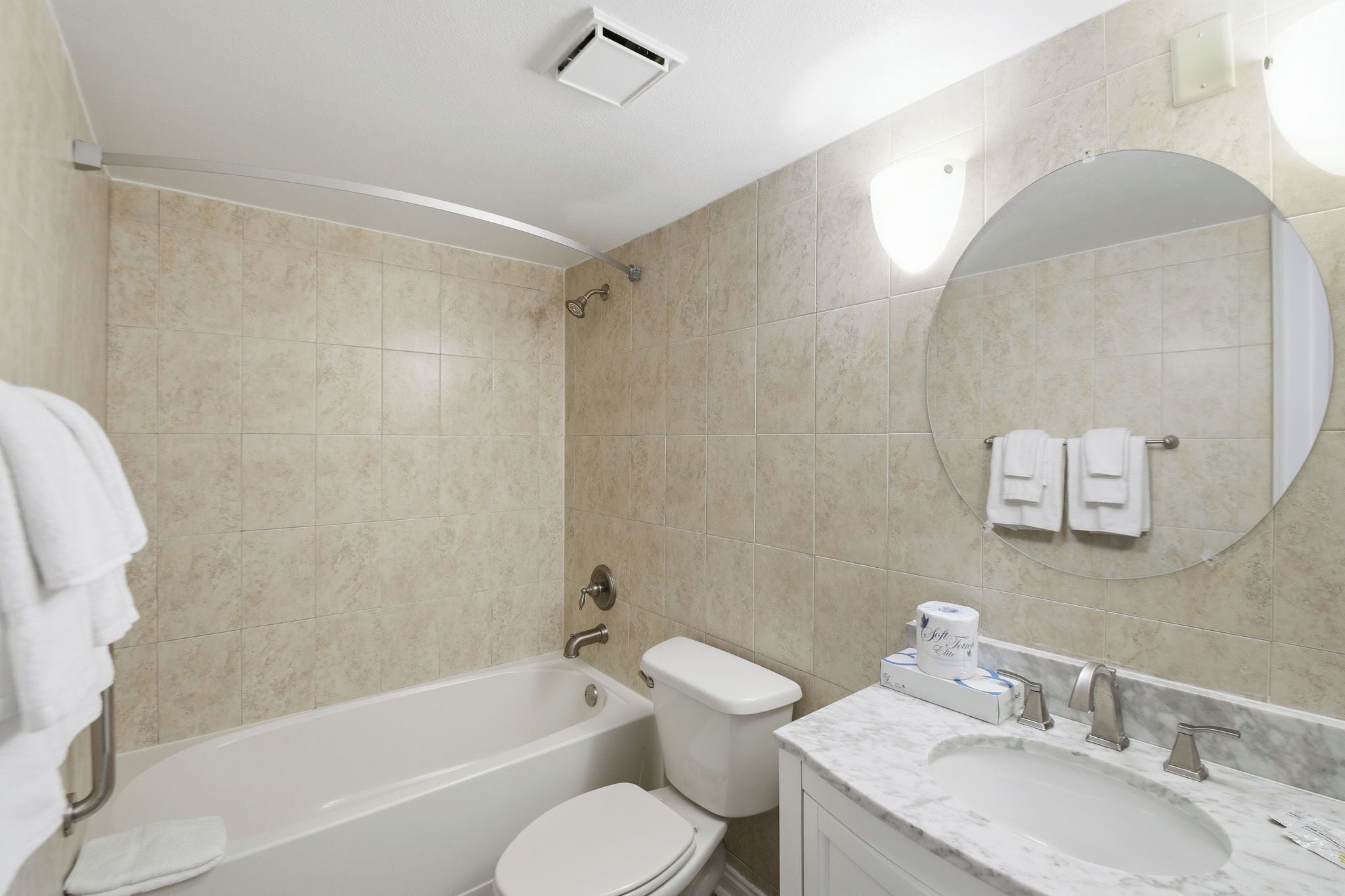 A modern bathroom with a bathtub, toilet, and sink.