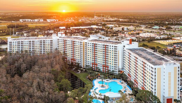 Un extenso complejo hotelero con varios edificios altos, una piscina central y zonas verdes circundantes.