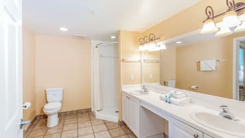 A bathroom with a toilet, sink, and shower.
