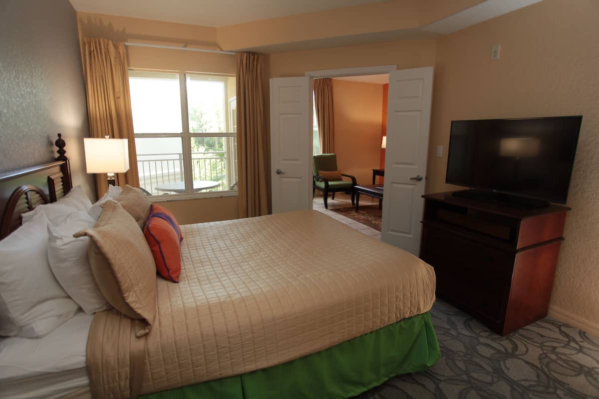 A hotel room with a bed, a television, a desk, and a chair.