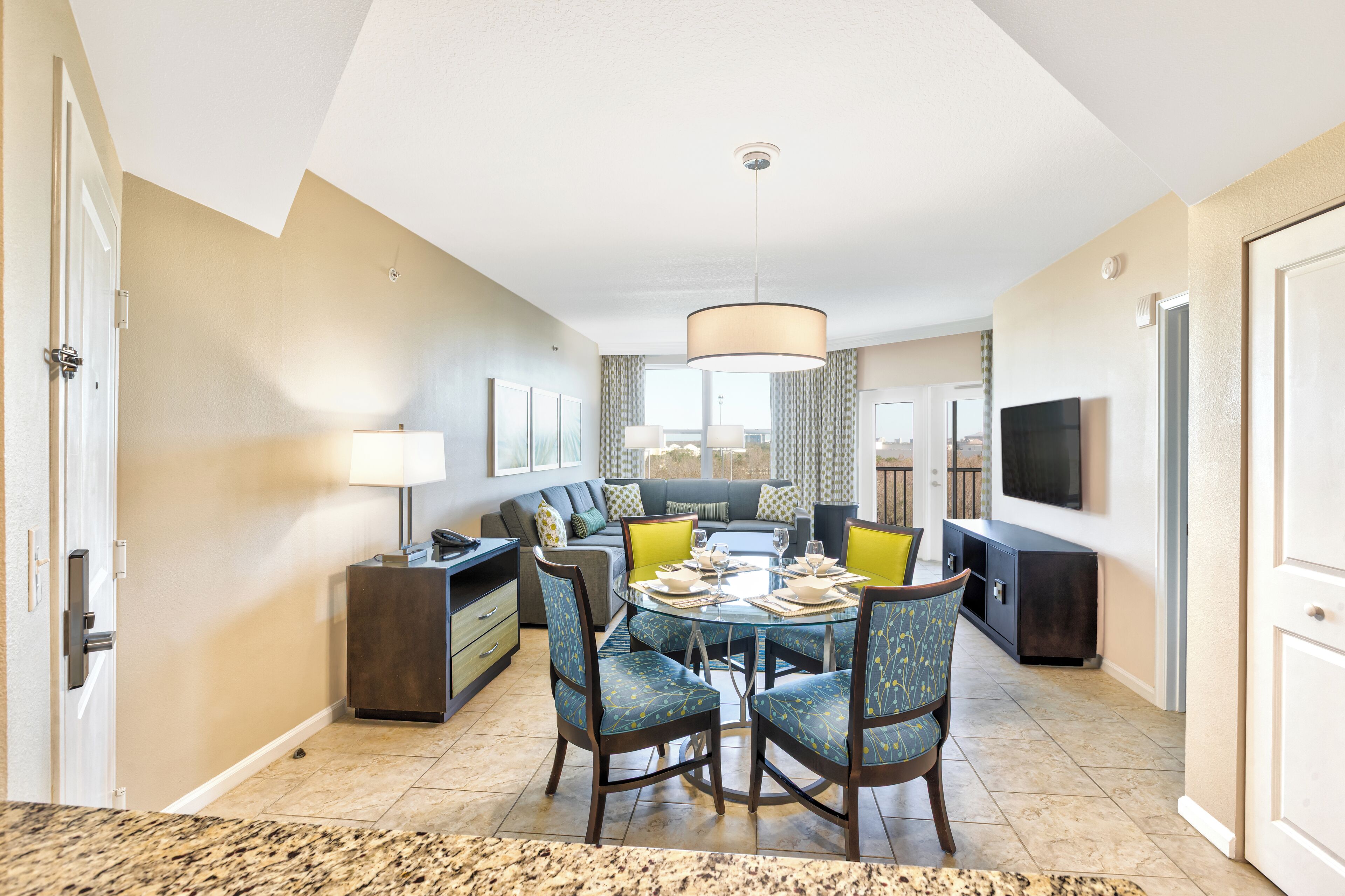 A modern living room with a dining area, a sofa set, and a television.
