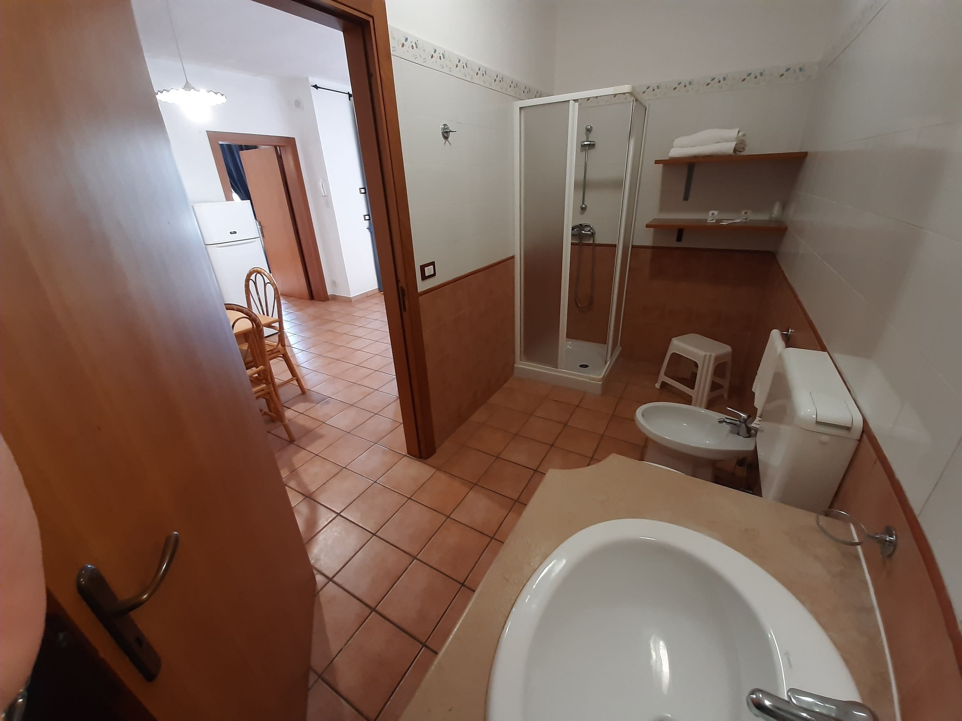 A bathroom with a shower, toilet, and sink.