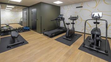 A gym with treadmills, elliptical machines, and weight equipment.
