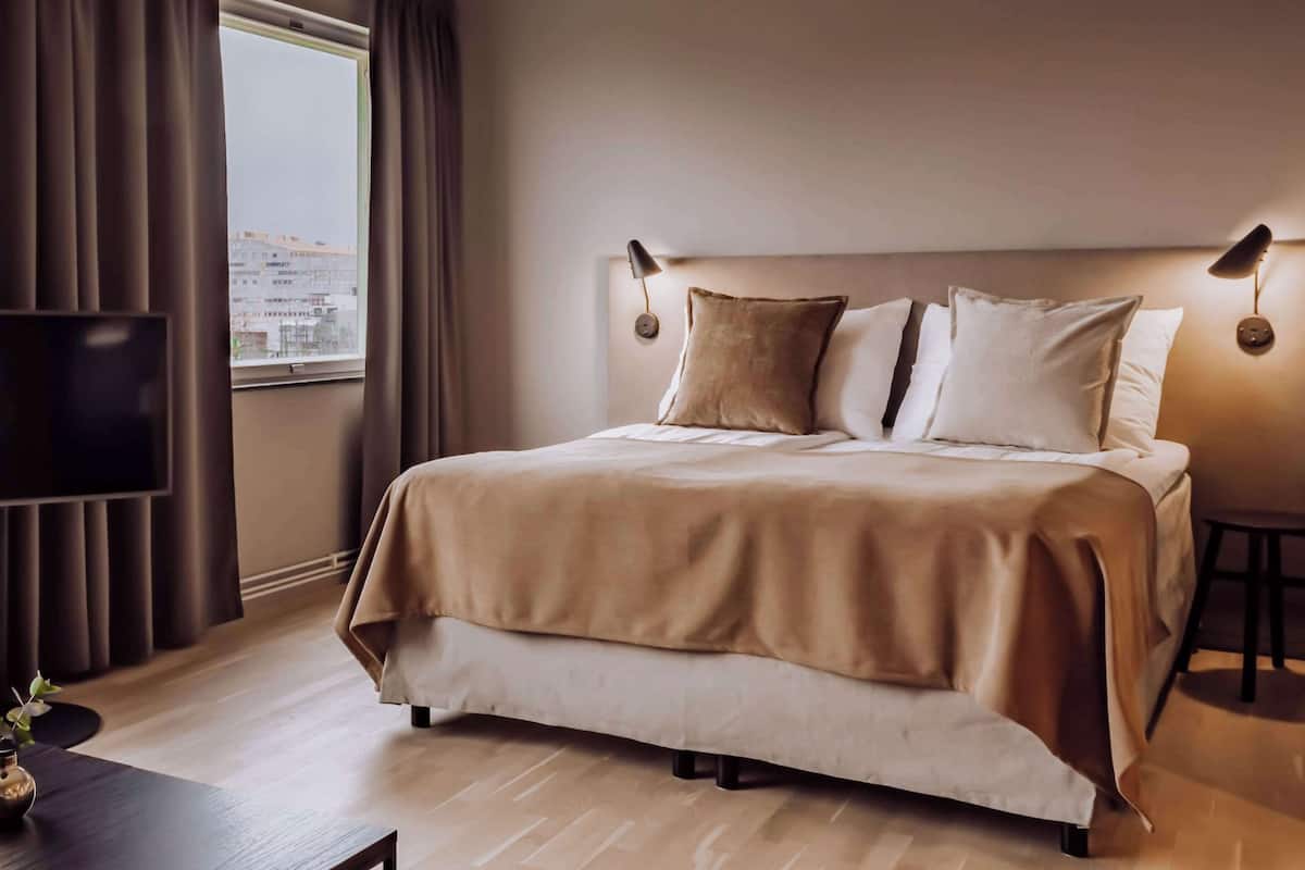 Escritorio, cortinas blackout y tabla de planchar con plancha