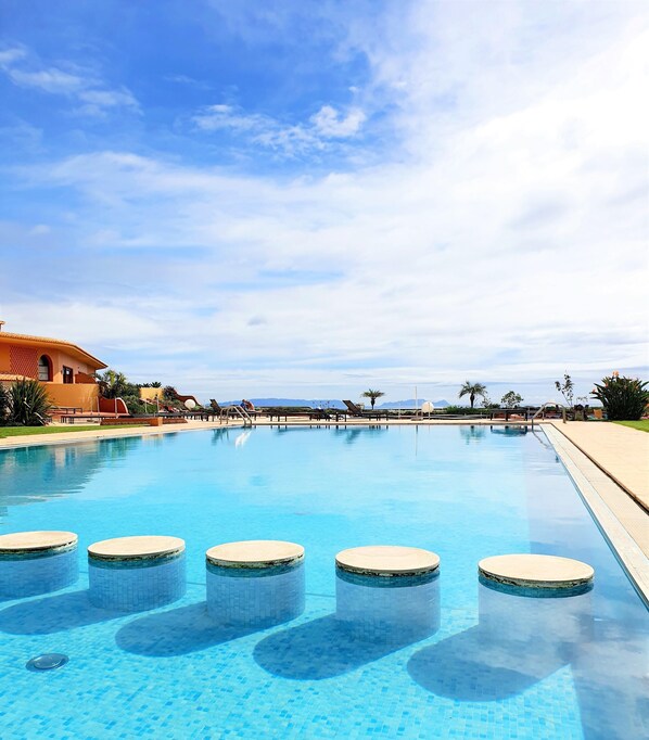 Piscine couverte, piscine extérieure, parasols de plage, chaises longues