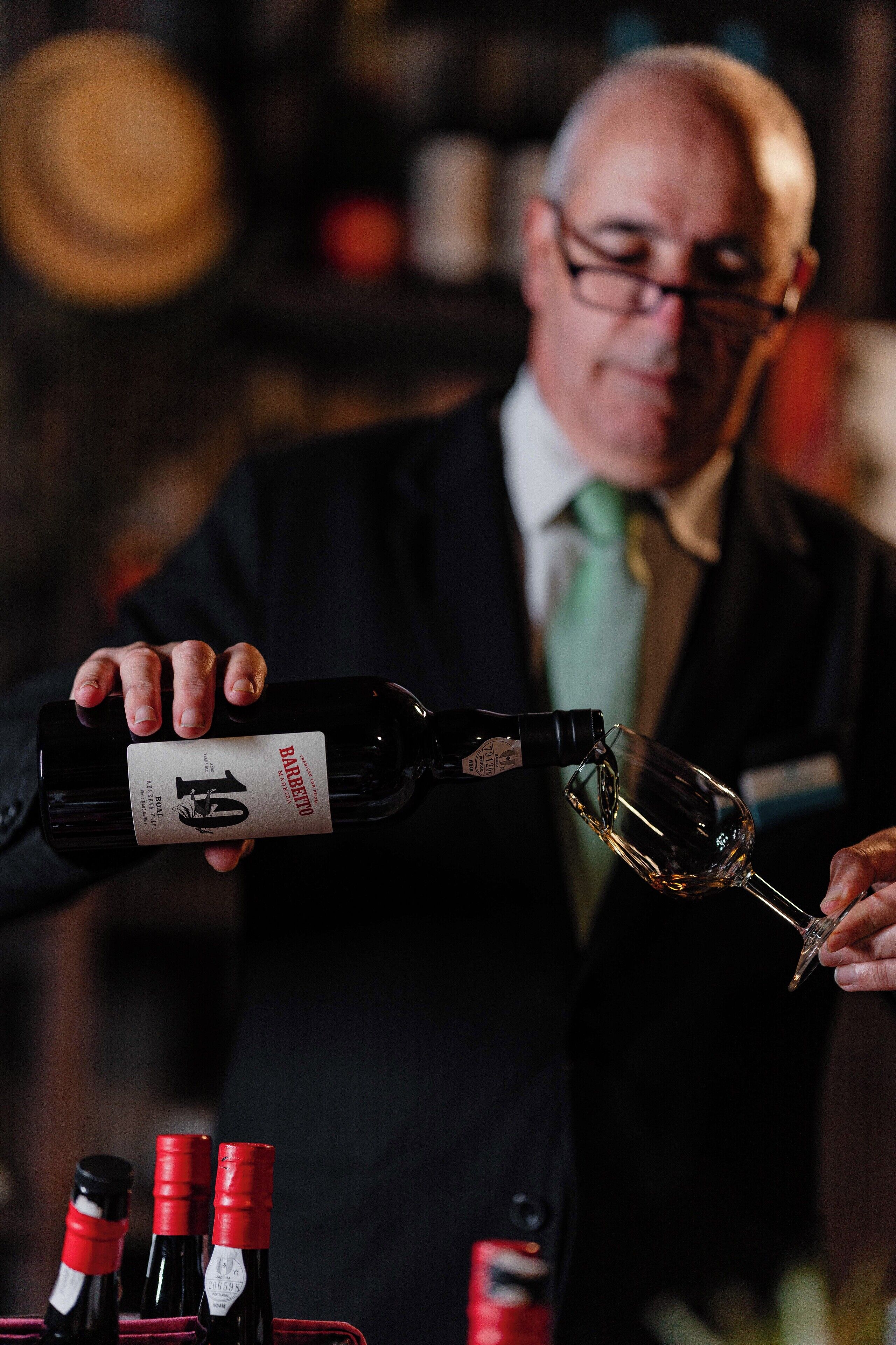 Eine Person gießt Wein in ein Glas.