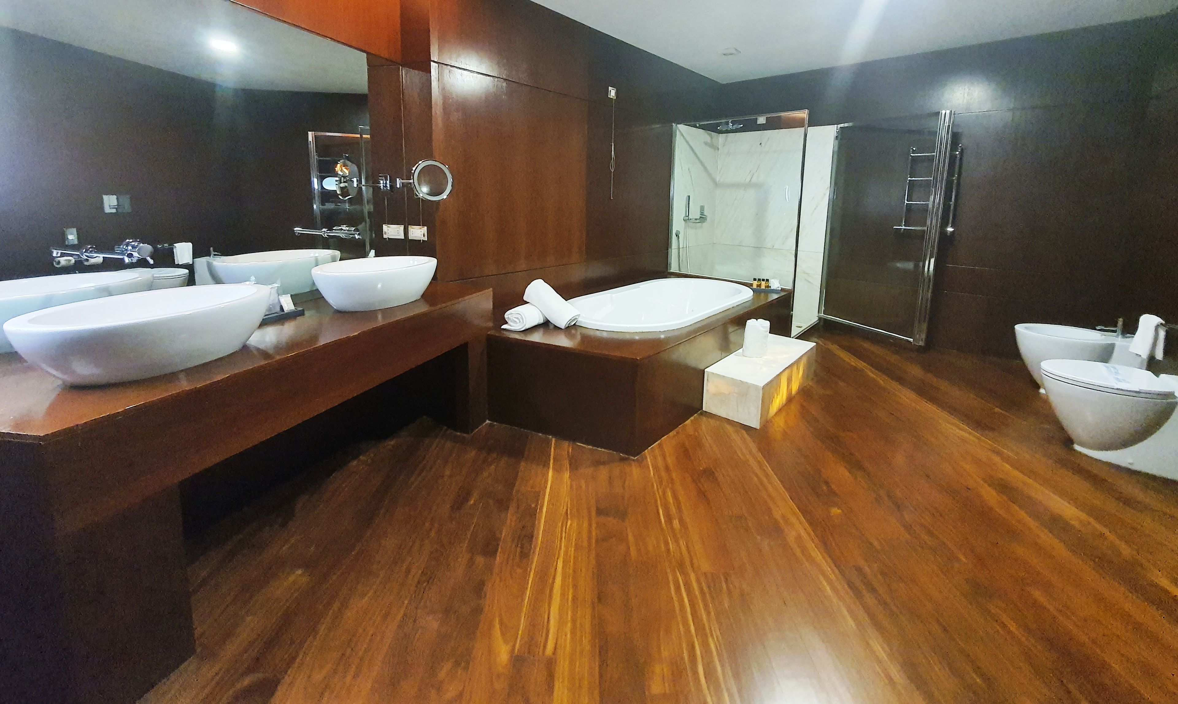 Une salle de bain moderne dotée d’une grande baignoire, de deux lavabos et d’une douche à l’italienne.