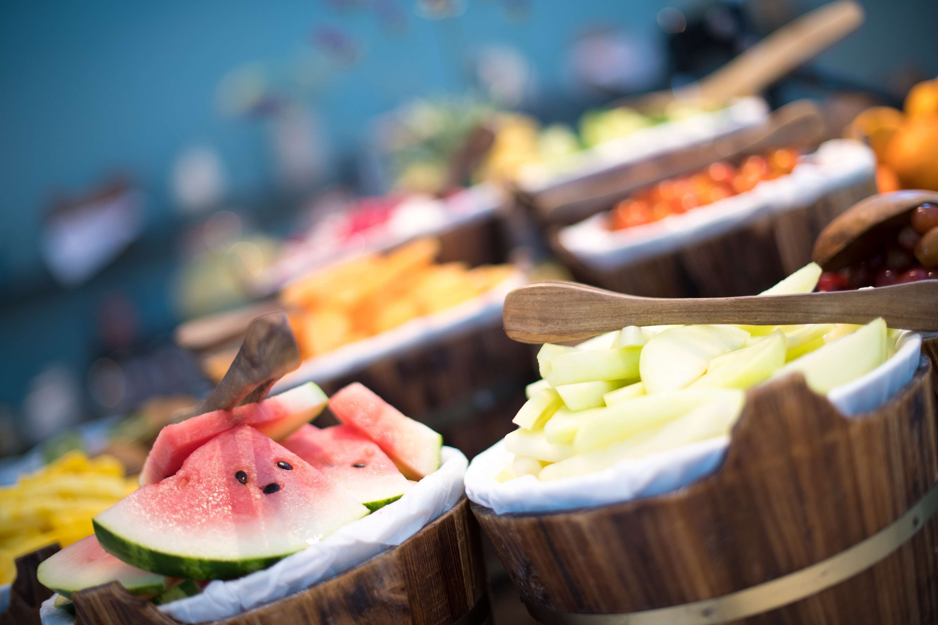 A variety of fruits in wooden bowls, including watermelon and melon.