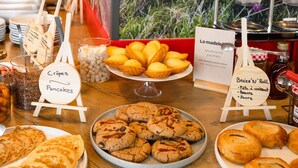 A buffet table with various baked goods, including crepes, pancakes, and cookies.