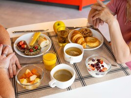 Una escena de desayuno con diferentes alimentos y bebidas sobre una mesa.