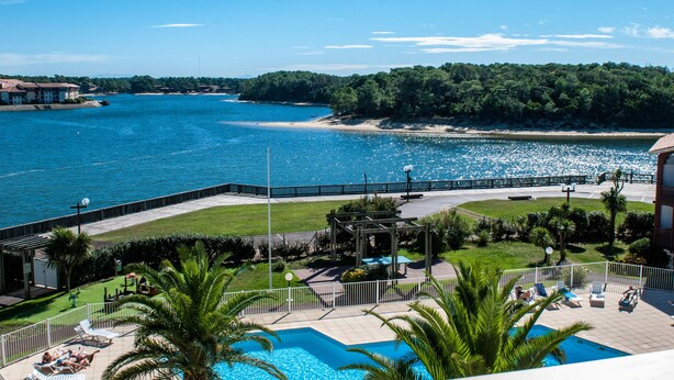 A pool area with lounge chairs and a view of the sea. - Résidence Le Boucanier (Vieux-Boucau-les-Bains)