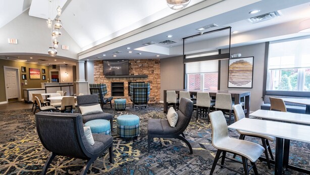 A modern conference room with a fireplace, comfortable seating, and a large window providing natural light. - Residence Inn by Marriott Princeton at Carnegie Center (Princeton)