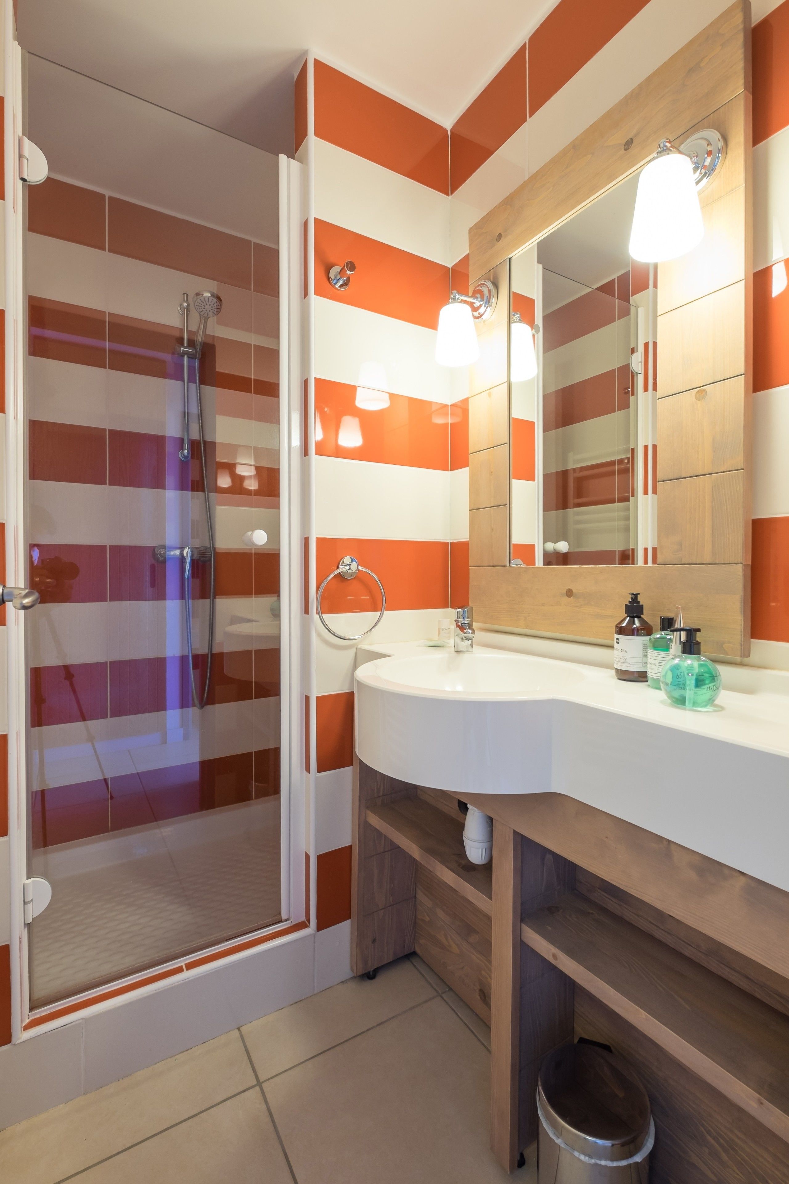 Une salle de bain avec une douche, un lavabo et un miroir.