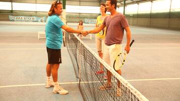 Ein Tennisplatz mit Netz, eine Powerade-Werbung und eine Gruppe von Menschen, die einander die Hand geben.