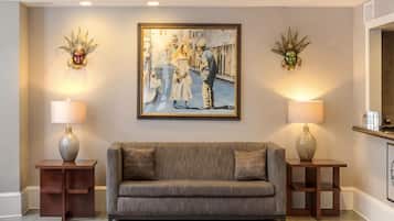 Un salon comprenant un canapé, deux tables d’appoint avec des lampes et un tableau encadré accroché au mur.