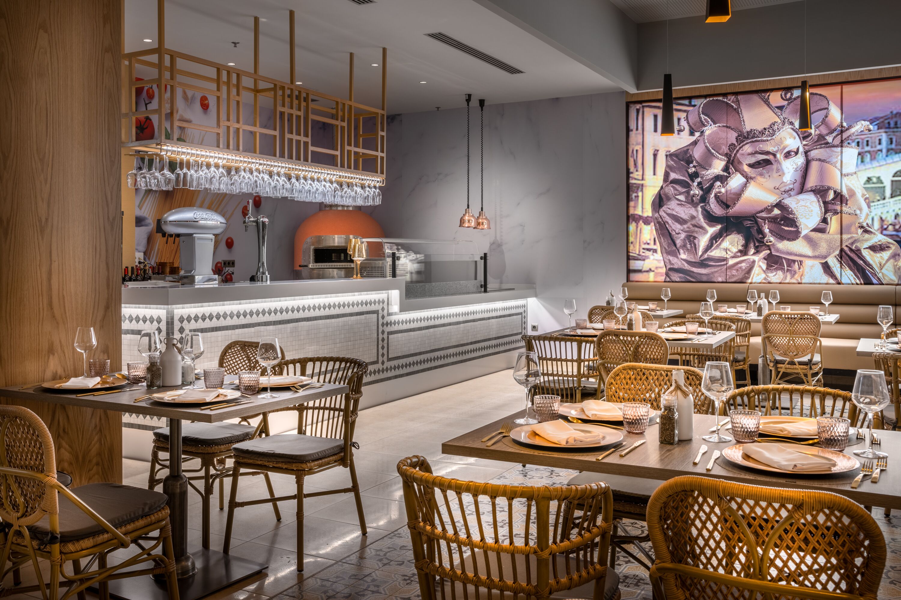 A restaurant with wicker chairs, a bar area, and a large mural on the wall.