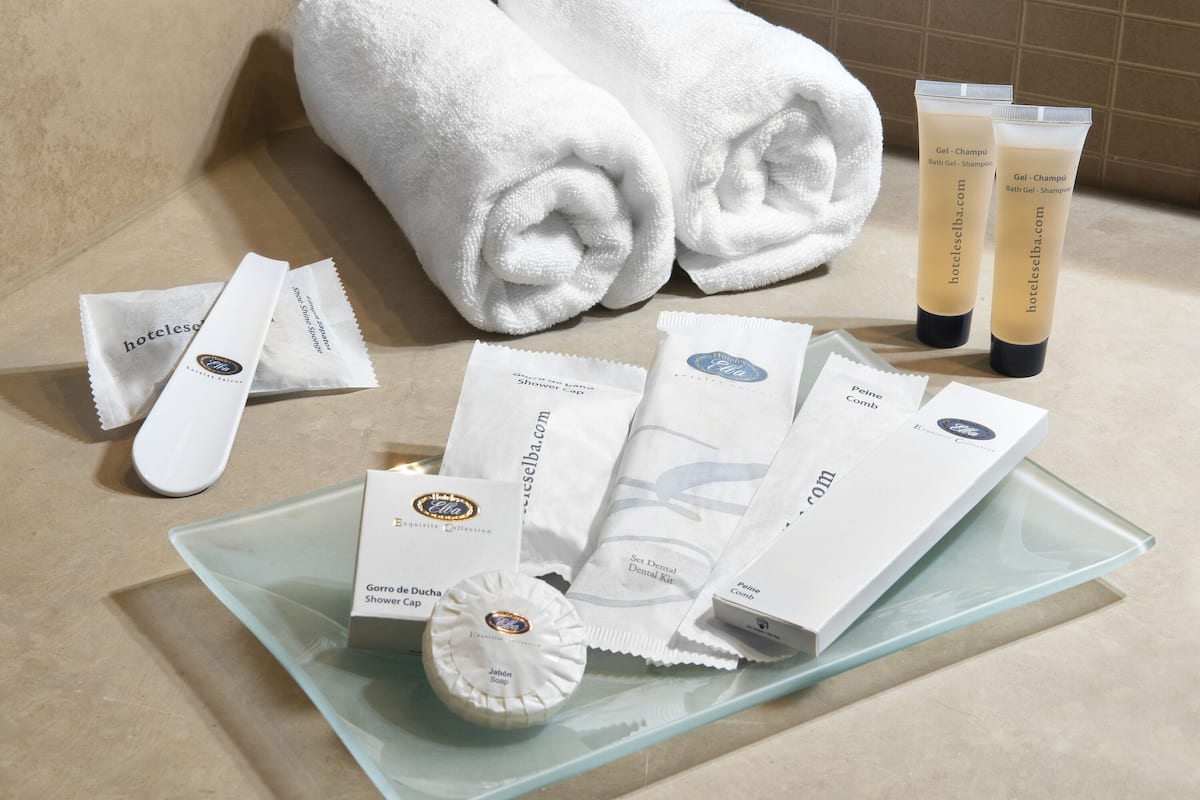 Toiletries and a shower cap on a glass tray.