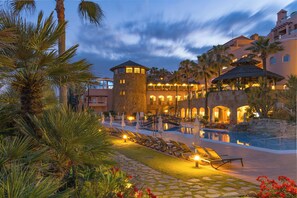 A resort with a pool, palm trees, and a tower. - Gran Hotel Elba Estepona Thalasso & Spa (Estepona)