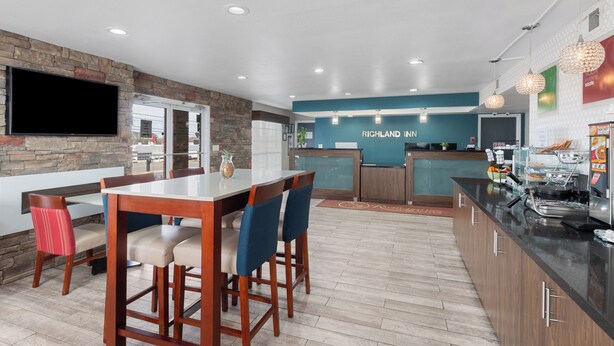 Una cocina moderna con un muro decorativo de piedra, una zona de bar y un televisor de pantalla plana.