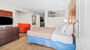 Una habitación de hotel con cama, televisión, escritorio y silla.