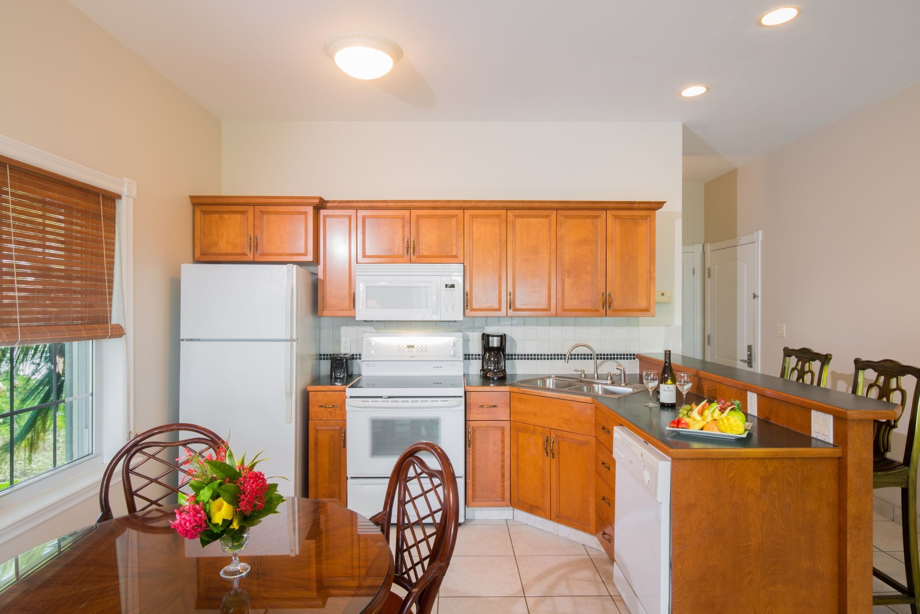 A kitchen with wooden cabinets, a white refrigerator, a microwave, a stove, and a dishwasher.