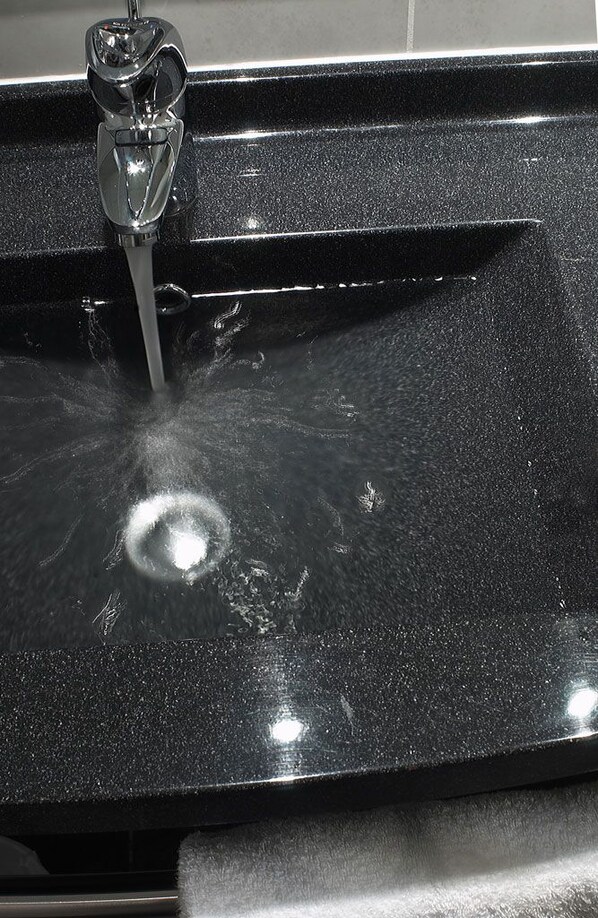 A black granite sink with a modern faucet.
