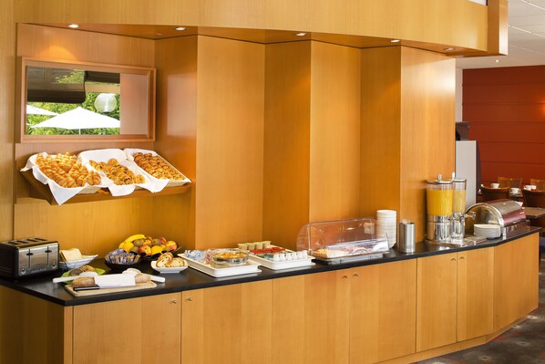 A breakfast buffet with various food items, a coffee station, and a toaster.