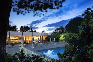 A poolside area with outdoor seating and a building in the background.
