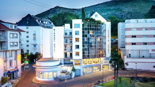 Un hotel moderno con un atrio central, varios pisos y vistas a la montaña.