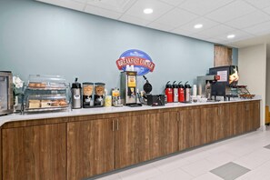 A breakfast counter with a sign reading "Breakfast Corner," coffee machines, and a variety of food items. - Baymont by Wyndham Grovetown Augusta (Grovetown)