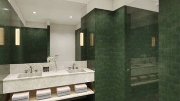 Enjoy a sophisticated bathroom experience with a sleek vanity, large mirror, and shelf for towels.