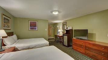 A hotel room with two beds, a desk with a chair, a TV, a dresser, and a microwave.