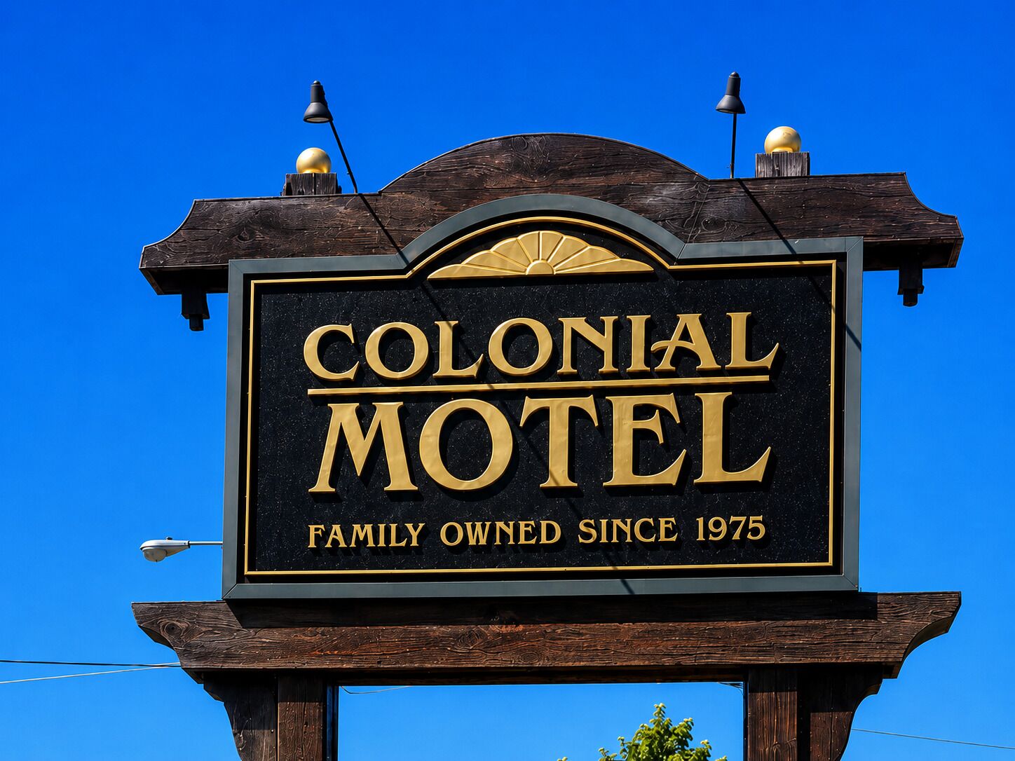 A sign for Colonial Motel with a family-owned logo since 1975.