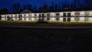 A motel with multiple floors, each with balconies and windows. - Colonial Motel (Brattleboro)