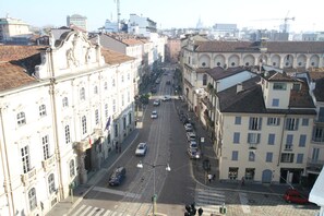 A street view of a city with historic buildings, a tram line, and parked cars. - Mokinba Hotels King (Milan)