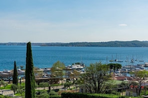 A marina with boats, a clear sky, and a distant hilly landscape.