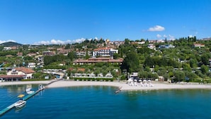 Eine Küstenstadt mit einer Marina, Strand und Häusern am Hang.