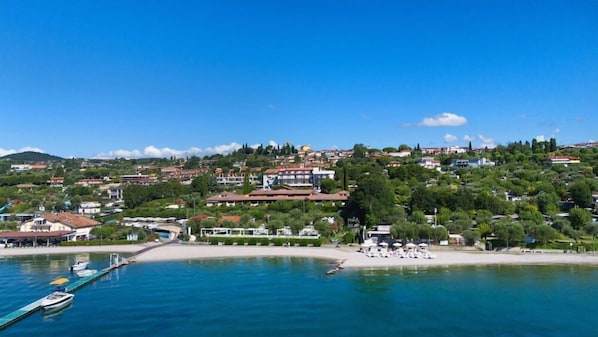 A coastal town with a marina, beach, and hillside buildings.